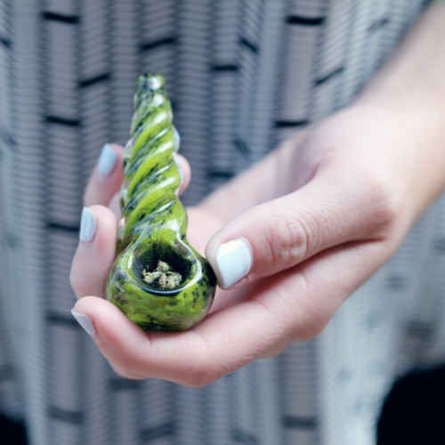 Holding a glass pipe with weed in the bowl