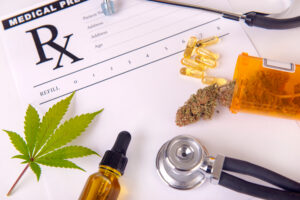 A prescription pad with several different marijuana products on top. Weed may relieve nausea.