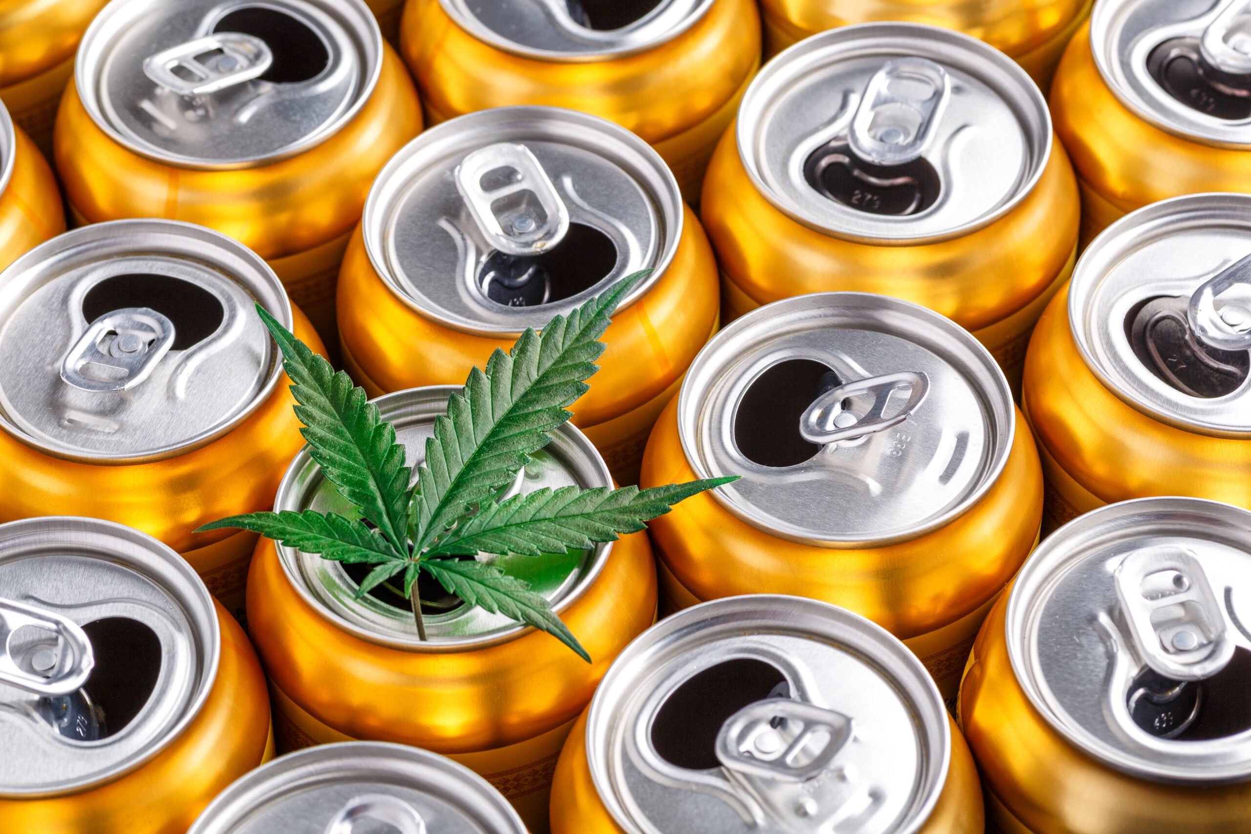 Gold colored cans with a marijuana leaf sitting on top