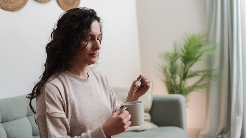 Woman adding a THC tincture in her tea