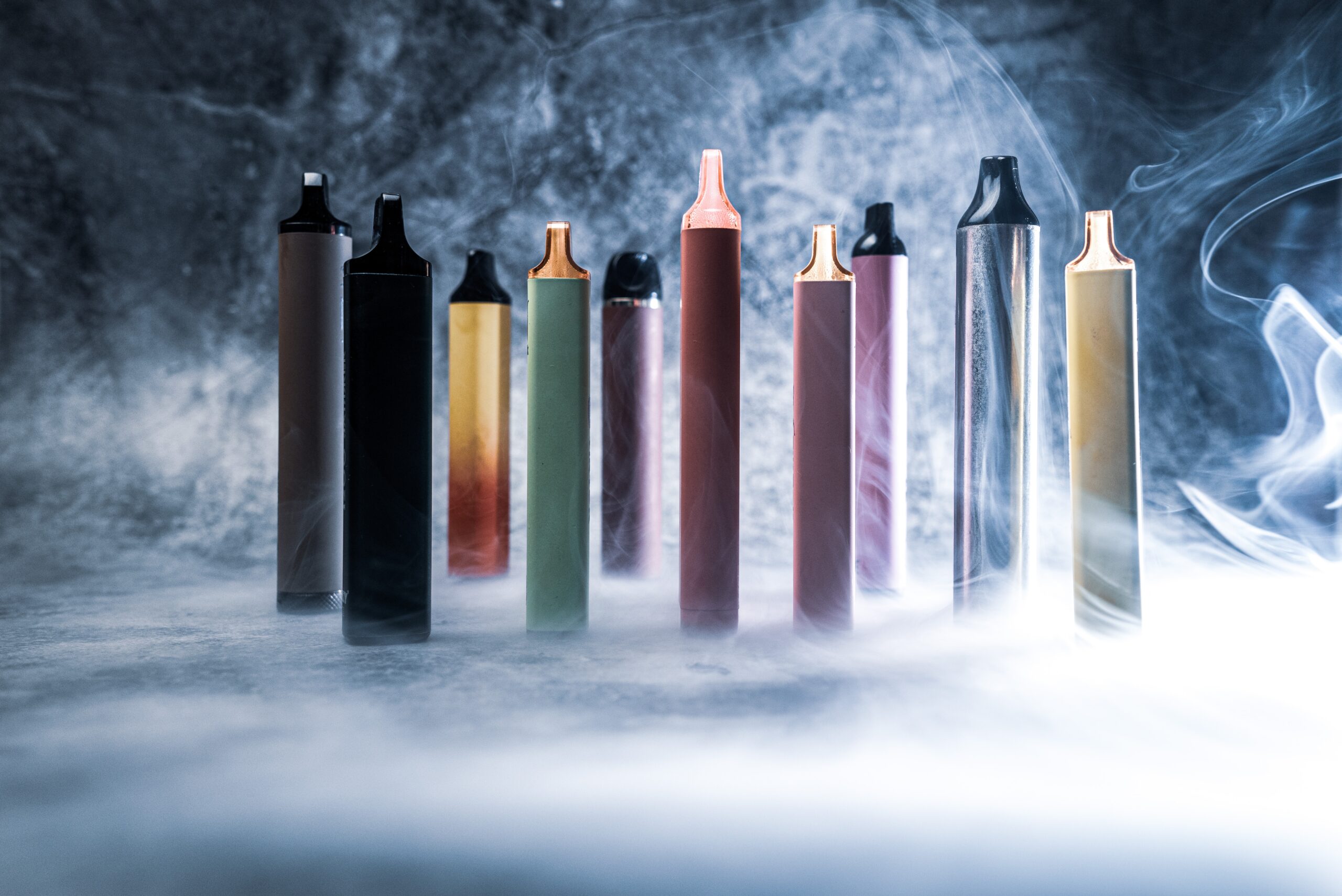 Vape pens sitting in a haze of smoke